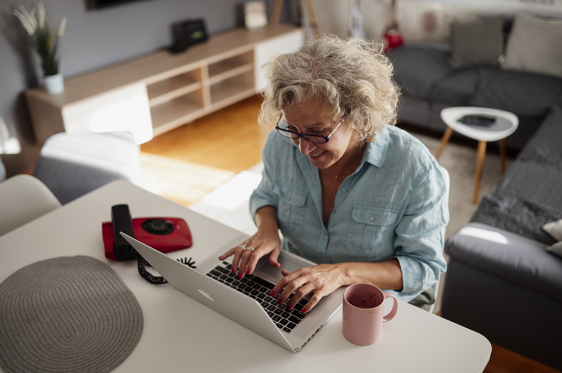 A woman comfortably using her laptop at home